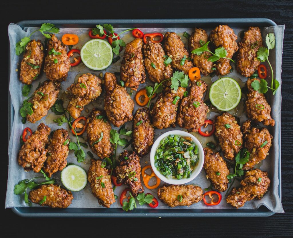 fried chicken on tray with limes, peppers, cilantro and sauce; healthy air fryer chicken recipes concept